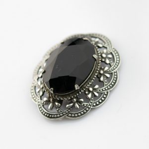 Metal brooch with black stone